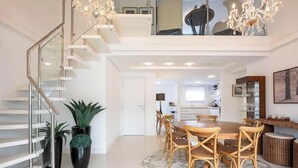 A modern interior with a staircase, dining area, and kitchen. - Apto c/ piscina e churrasq, 280m da praia IMD0502 (Bombinhas)