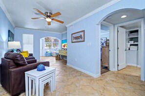 A spacious living area with a ceiling fan, a couch, a small table, and a kitchen visible through an open door. - 1st floor condo with private dock easy beach access heated pool and patio (Indian Shores)