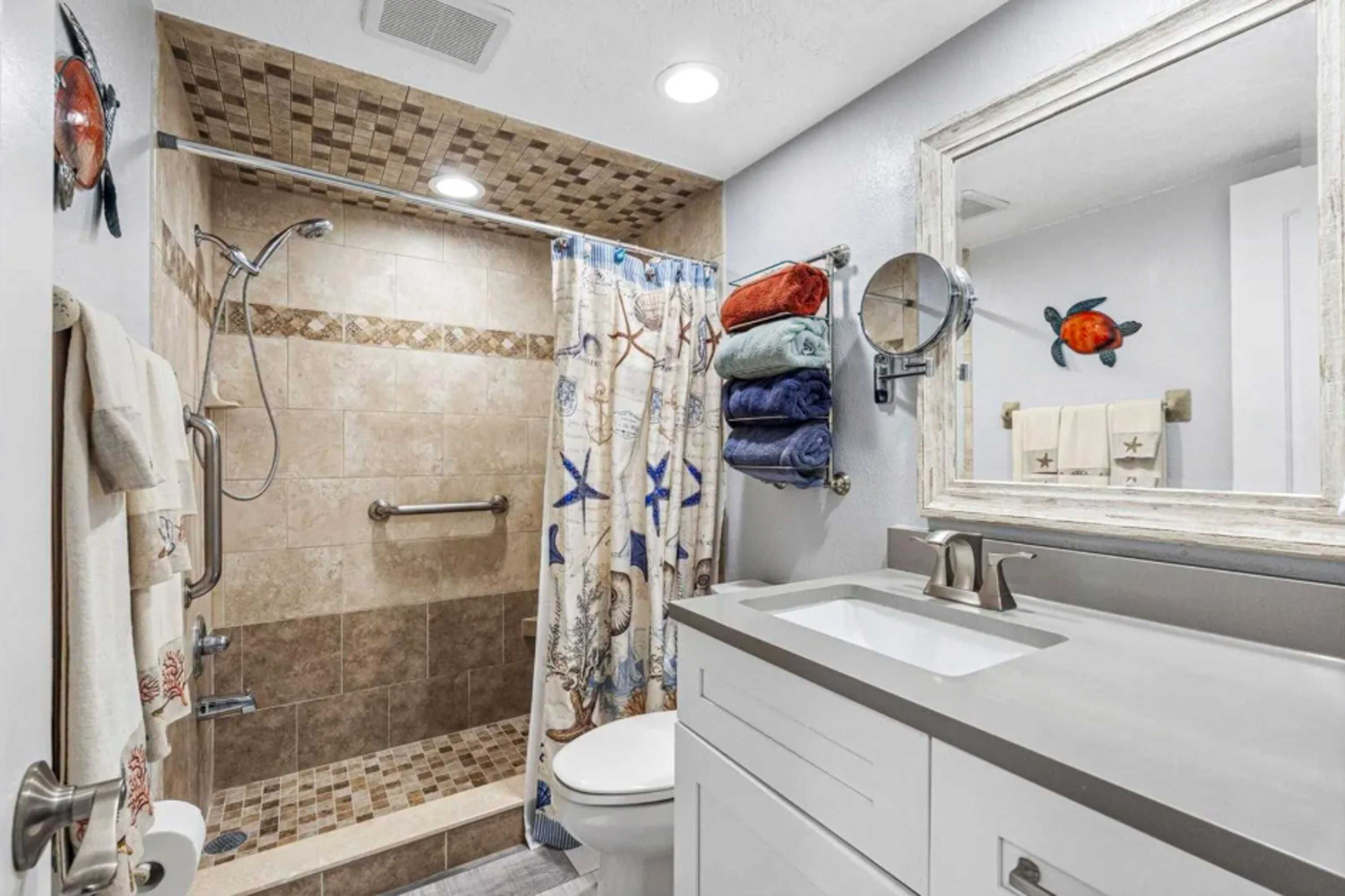 A bathroom with a shower, toilet, and sink.