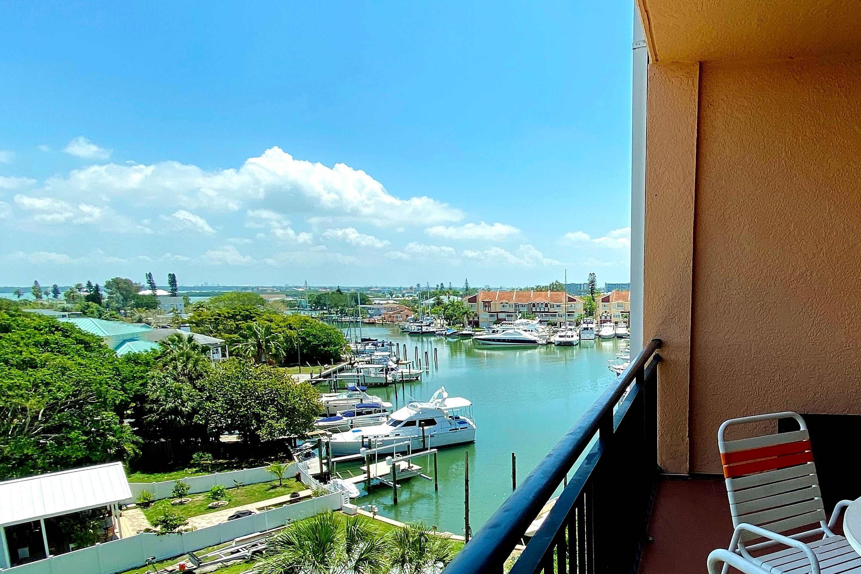Een balkon met uitzicht op een jachthaven, boten en gebouwen.
