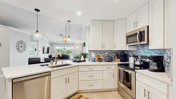 Una cocina moderna con armarios blancos, electrodomésticos de acero inoxidable y una isla grande.