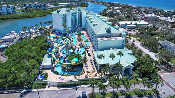 A resort with a large water park, multiple swimming pools, and a view of the ocean.