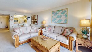 A living room with two sofas, a coffee table, and a lamp. - Waterfront condo with pool and spa directly across from wide beach (Indian Shores)