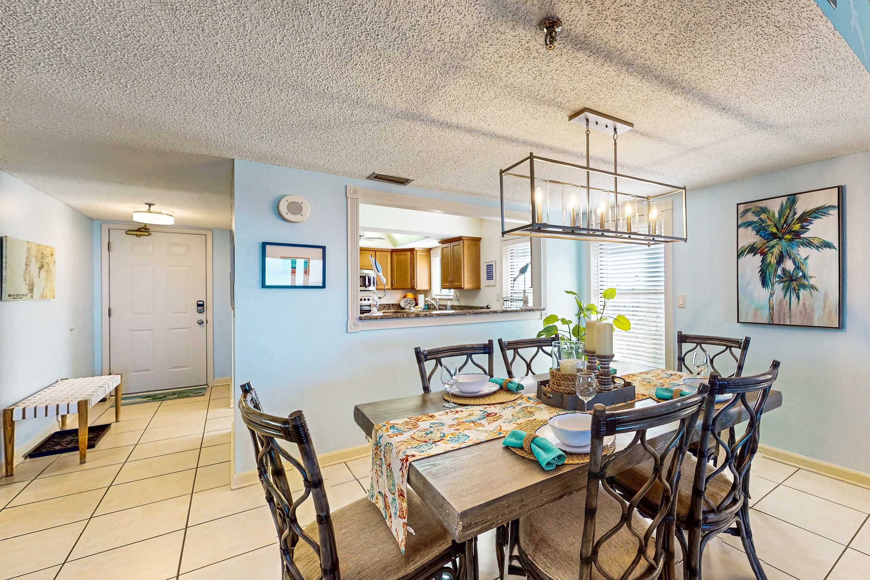 A dining area with a wooden table, chairs, and a chandelier.