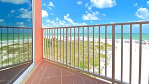 A balcony with a view of a beach and ocean. - Spacious cottage with glorious Gulf view and beachfront heated pool and spa (Indian Shores)