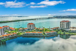 A waterfront hotel with multiple buildings, a bridge, and a calm body of water.