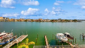 A marina with boats docked, a clear sky, and a cityscape in the background. - Waterfront Condo w WiFi Washer Dryer and Central AC Snowbird Friendly (Clearwater Beach)