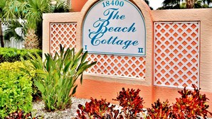 A sign for The Beach Cottage with the address 18400. - Dreamy condo with panoramic Gulf vIews and beachfront heated pool and spa (Indian Shores)