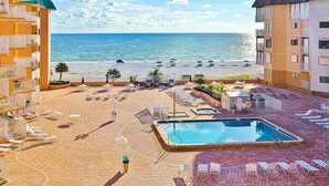 Ein Resort mit Schwimmbad, Blick auf den Strand und mehreren Liegebereichen.