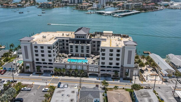 Un hôtel doté d’une cour intérieure, de plusieurs étages et offrant une vue sur le port de plaisance et les bateaux.