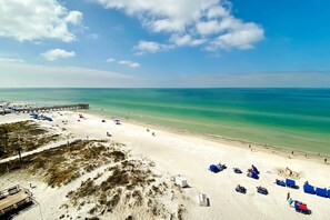 A beach with a pier, clear turquoise water, and sandy shore. - Water view condo with heated Gulf front private balcony and central AC (Indian Shores)