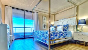 Une chambre moderne avec un grand lit, une table de chevet et une vue sur l’extérieur.