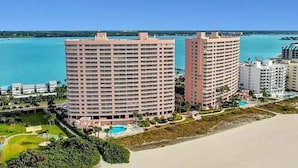 Un hôtel de grande hauteur doté de nombreux balcons, d’un espace piscine et offrant une vue sur la plage.