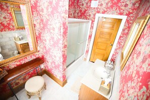 A bathroom with a shower, a sink, a toilet, and a vanity with a mirror.