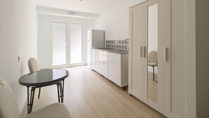 Una cocina moderna con armarios blancos, horno empotrado y salpicadero de azulejos.