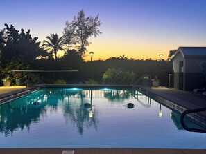 En swimmingpool med fri sikt mot himlen och de omgivande träden.