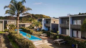 Ein modernes Resort mit mehreren Gebäuden, einem Pool und einem angelegten Garten.