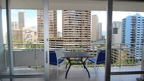 Un balcone con tavolo e sedie, con vista su edifici circostanti.