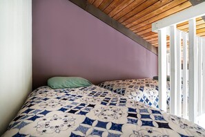 A bedroom with a purple wall, a wooden ceiling, and a bed with a patterned bedspread. - Kksr#6301 Ocean/golf Course Views, Top Floor (Kailua-Kona)