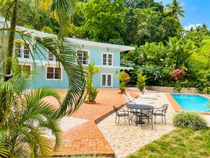 A two-story house with a swimming pool, outdoor seating, and lush greenery. - Torraille Waterfall Villas (Soufrière)