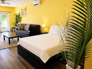 A room with a bed, a sofa, a small table, a lamp, and a potted plant. - Torraille Waterfall Villas (Soufrière)