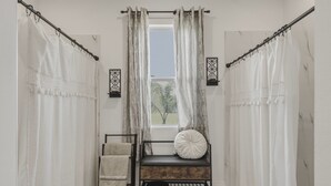 Una habitación con ventana, un banco con cojín y cortinas.
