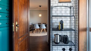 A kitchen with a metal shelf holding a kettle, toaster, and coffee maker. - The Porto Wine Cellars Penthouse (Vila Nova de Gaia)