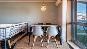A compact room with a bunk bed, a dining table with chairs, a hanging light fixture, and a large window offering a view of the outside. - The Porto Wine Cellars Penthouse (Vila Nova de Gaia)