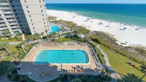 Vista aérea de um hotel com piscina, praia e oceano.