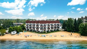 Un hôtel à plusieurs étages avec vue sur la plage, situé près d’une étendue d’eau.