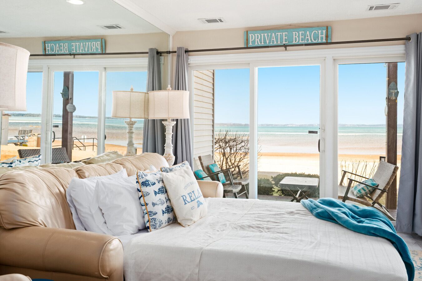 Ein Schlafzimmer mit einem großen Bett, Meerblick und einem Schild, das einen privaten Strand kennzeichnet.