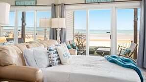 Une chambre avec un grand lit, une vue sur la plage et un panneau indiquant qu’il s’agit d’une plage privée.