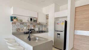 Een moderne keuken met een centraal eiland, roestvrijstalen apparatuur en een decoratieve spatwand.