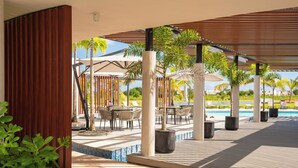 Un espacio al aire libre techado con asientos y piscina.