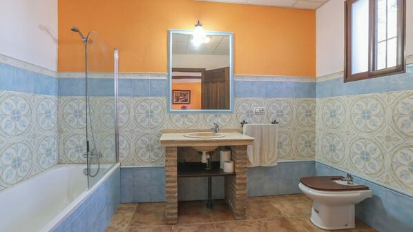 A bathroom with a bathtub, a sink, a toilet, and a shower.