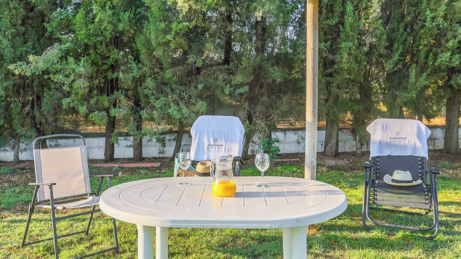 An outdoor seating area with a round table, two chairs, and a covered tablecloth.