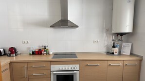 A modern kitchen with a built-in oven, a range hood, and a water dispenser. - Beautiful triplex with sea views in Mijas Costa Calalucia! (Mijas-Costa)