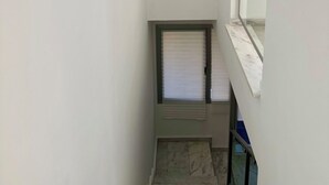 A narrow stairway with a window at the top and a door at the bottom. - Beautiful triplex with sea views in Mijas Costa Calalucia! (Mijas-Costa)
