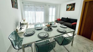 A dining area with a glass table set for four, surrounded by green chairs. - Beautiful triplex with sea views in Mijas Costa Calalucia! (Mijas-Costa)