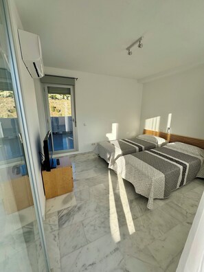 Une chambre à coucher avec un lit, une fenêtre et un ventilateur de plafond.