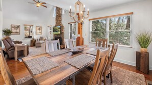 A dining area with a wooden table, chairs, and a chandelier.