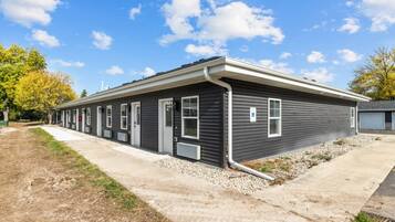 A row of single-story mobile homes with a concrete pathway in front.