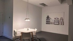 Un espace repas comprenant une table ronde, des chaises et un luminaire suspendu.