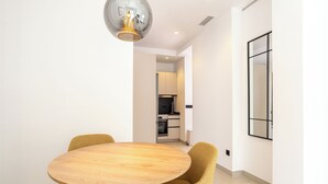A modern dining area with a round wooden table and yellow chairs. - 2-bedroom apartment in fantastic Malaga (Málaga)