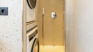 A compact bathroom with a washing machine, a shower, and a towel rack. - 2-bedroom apartment in fantastic Malaga (Málaga)