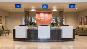 Un área de recepción con un letrero de 'Worldmark by Wyndham', dos mostradores de recepción y un mostrador de salida.