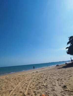 Ein Strand mit blauem Himmel und ruhigem Wasser.