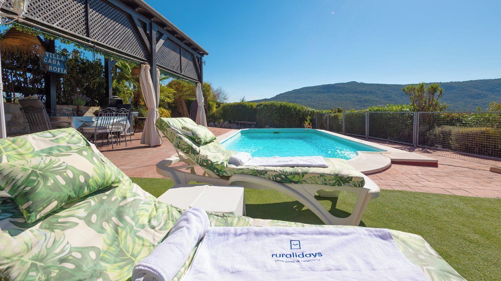 A poolside area with lounge chairs and a sign reading 'Villa Casa Sofia'.