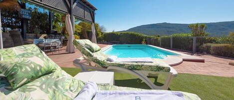 A poolside area with lounge chairs and a sign reading 'Villa Casa Sofia'.