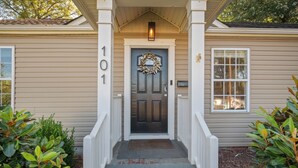 A house with a front door, a number '101' on the wall, and a small porch with steps leading to the door. - Bright & Stylish Home near Uptown - 3BR 2B + Outdoor (Charlotte)